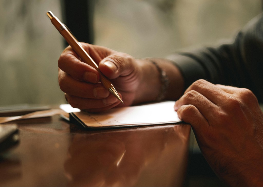 Hands carefully writing plans on paper